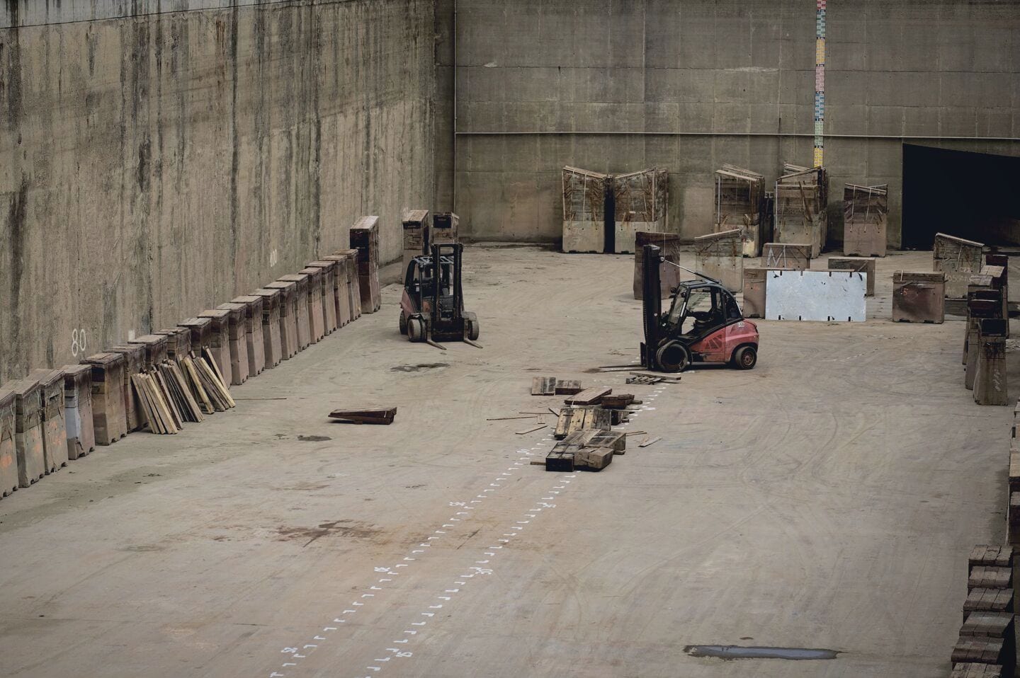Operators running forklifts on a warehouse floor